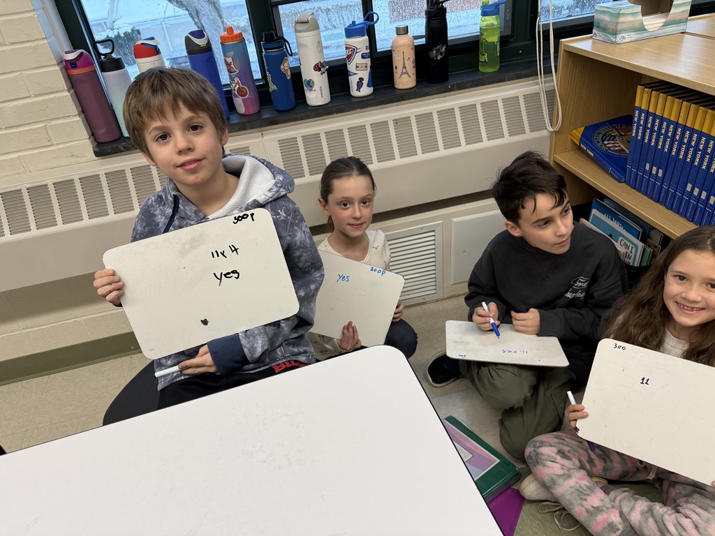 students writing down their answers on their board