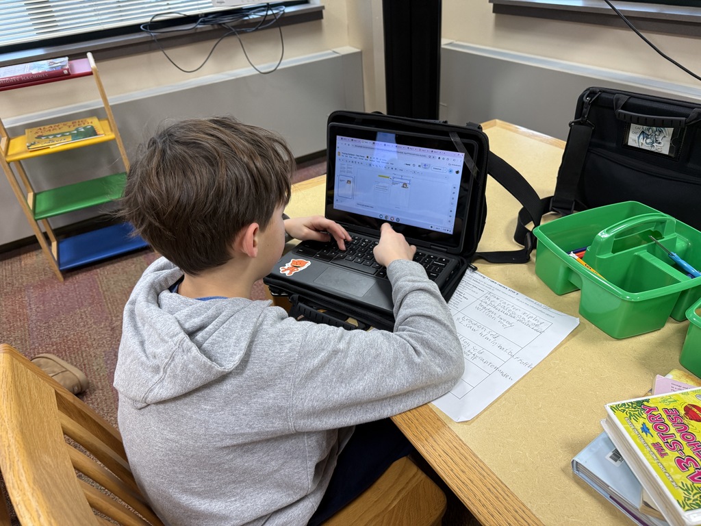 student writing a story on his Chromebook