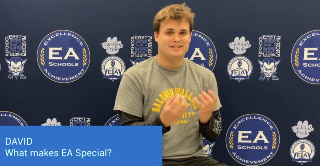 A student sitting in front of an EA Logo backdrop during recording
