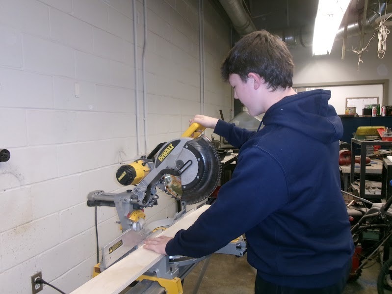 Student cutting wood for BDD