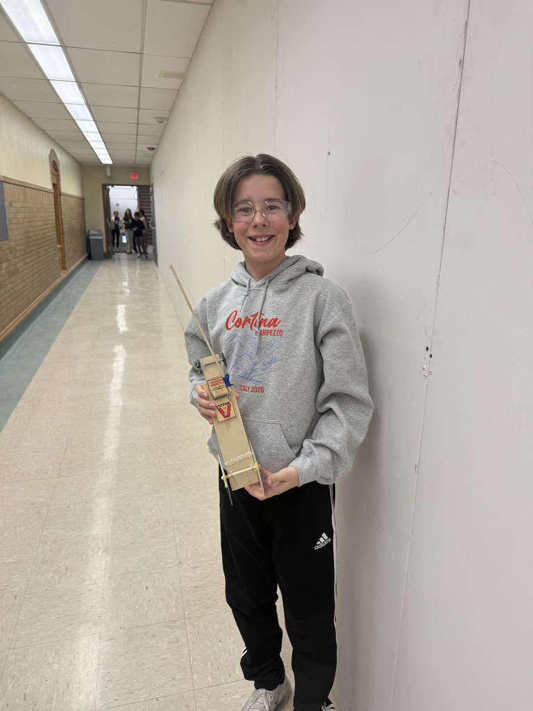 student holding his mouse trap car