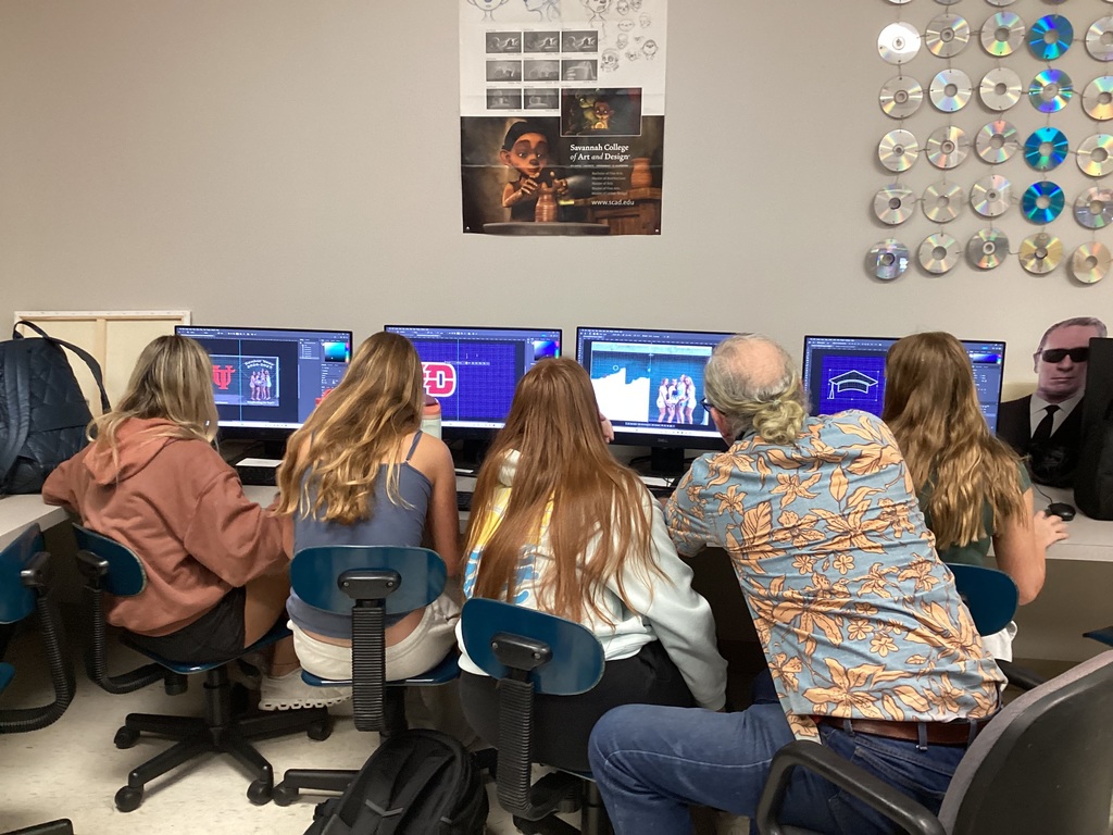 Highschool students working on their personal yearbooks on computers