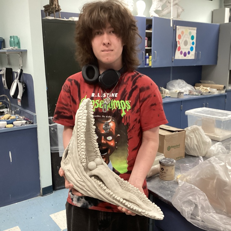 a student holding his ceramic project