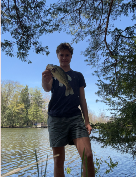 Adventure club student holding a fish he caught