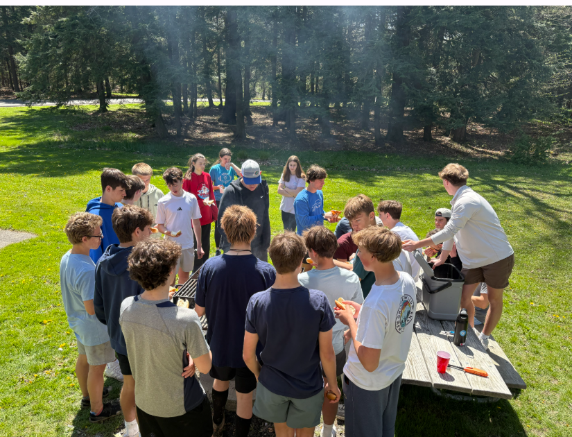 Adventure club students cooking hot dogs