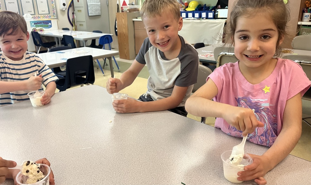 students smiling at a table eating ice cream