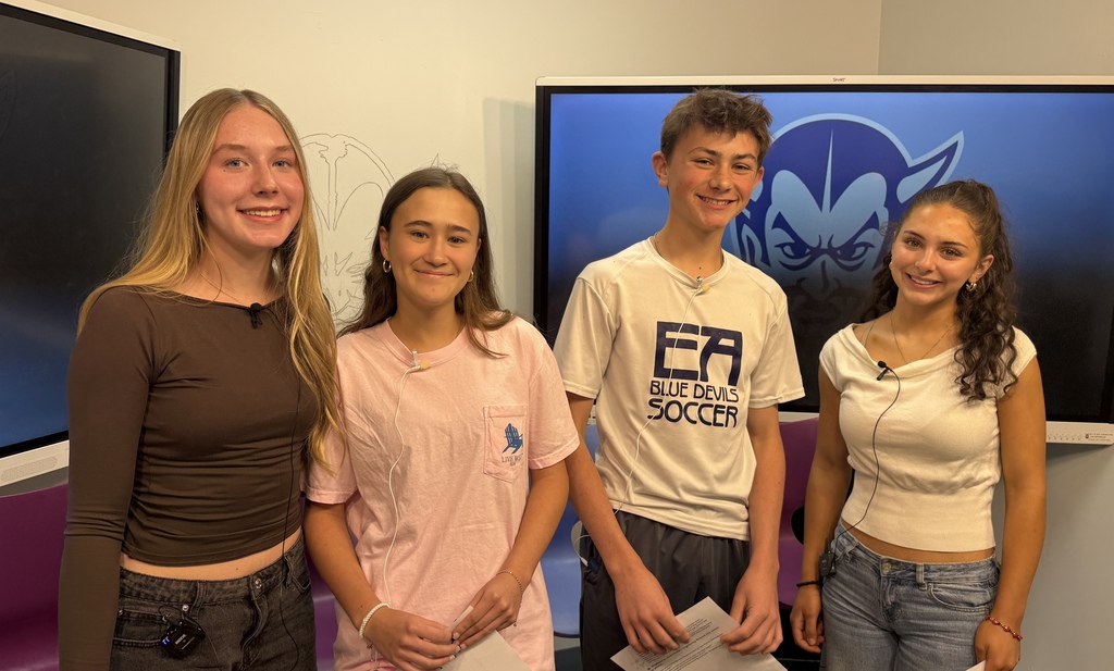 four students smiling standing in the broadcast studio