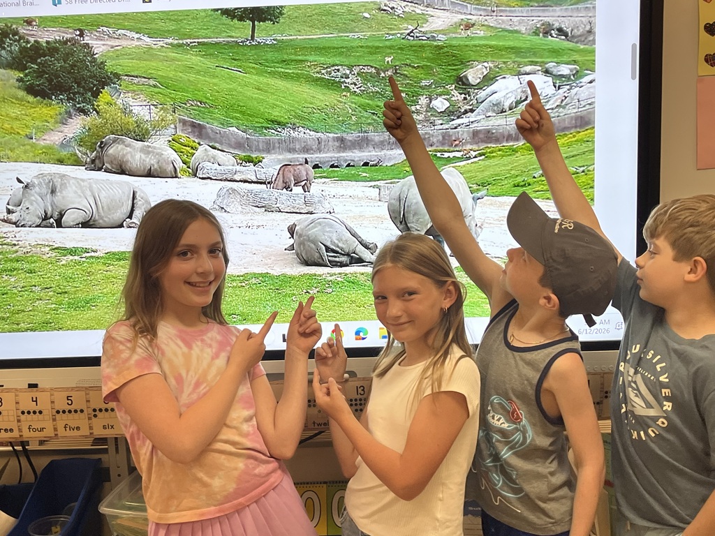 students pointing to a smartboard