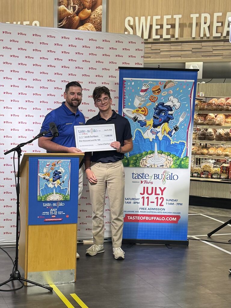 Jacob holding his award with a Tops rep