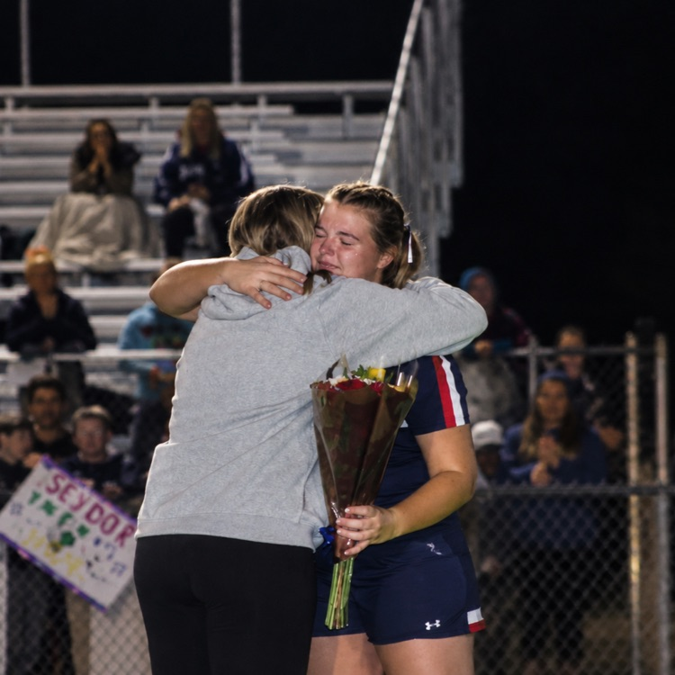 Soccer player, hugging coach