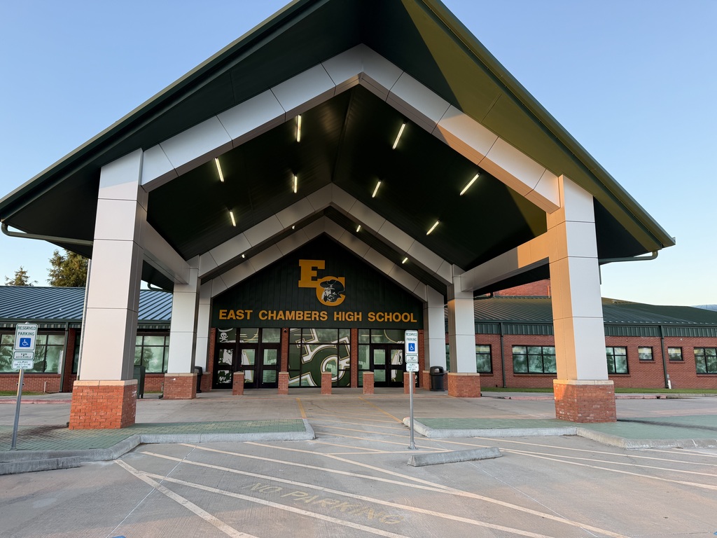 Entrance to East Chambers High School with a triangular roof, columns, and a sign. The building has a brick base.