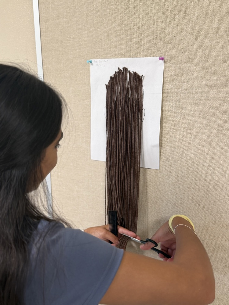 Cosmetology student learning to cut hair