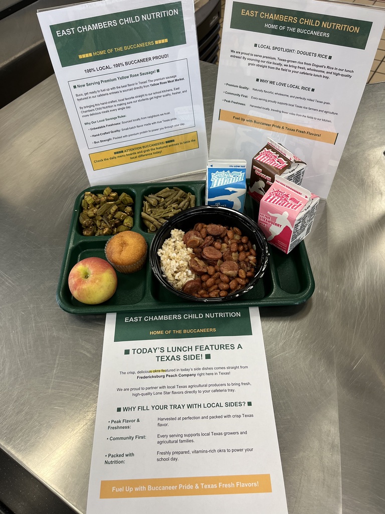 A lunch tray with mixed nuts, a fruit salad, and two informational cards is on a metallic surface.