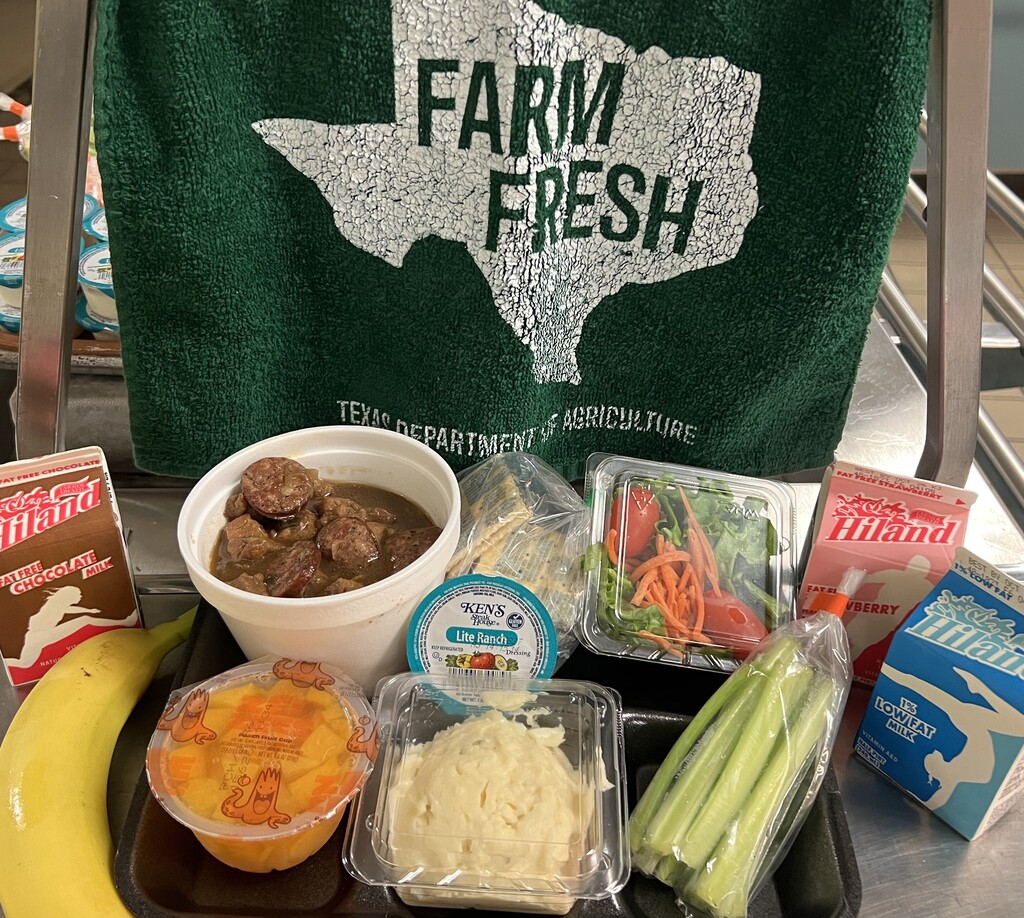 Tray with various food items, a banana, and a towel. Towel reads "FARM FRESH" in white over a Texas outline.