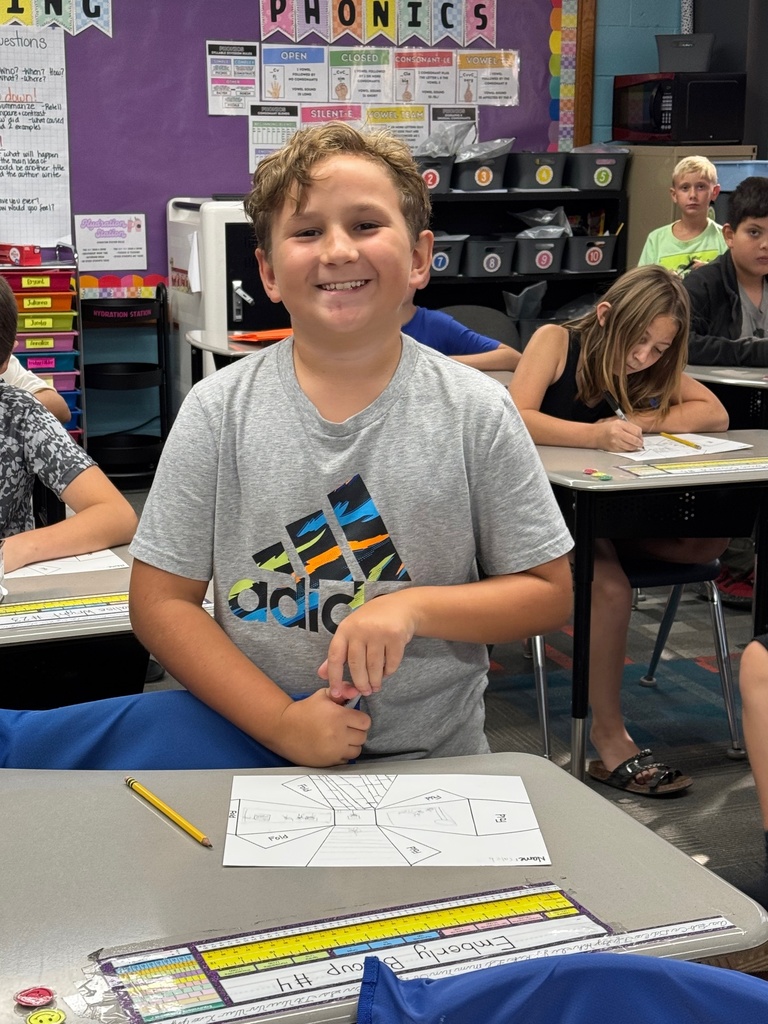 Student happily showing off his work