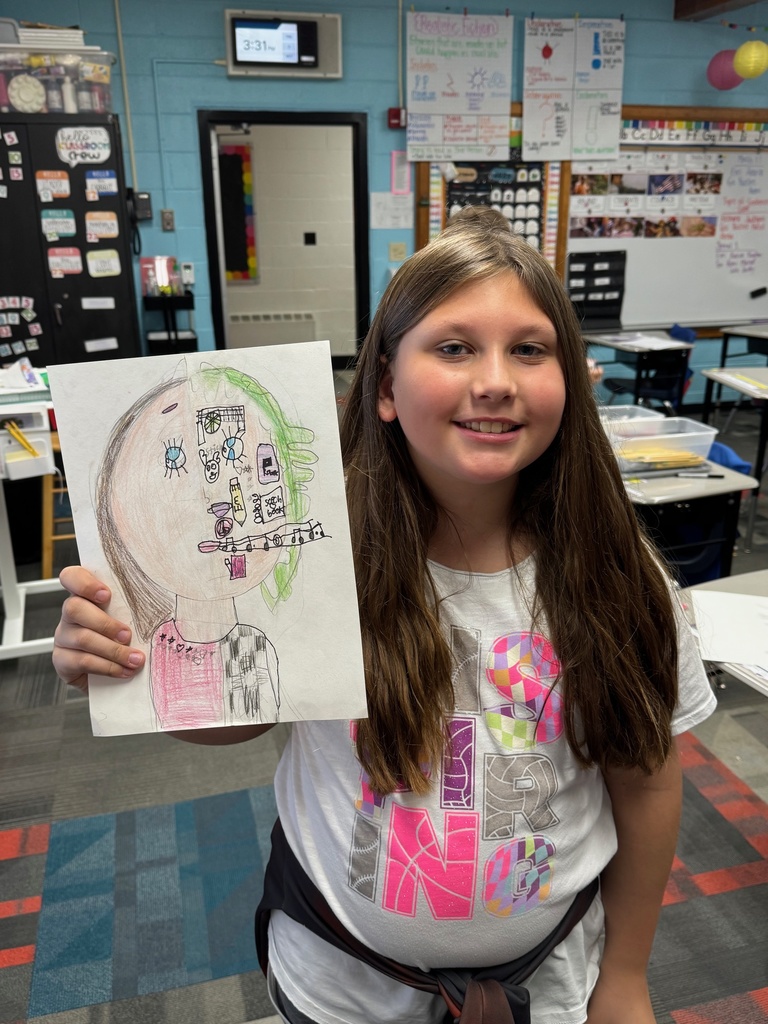 Third-grader showing off her self portrait