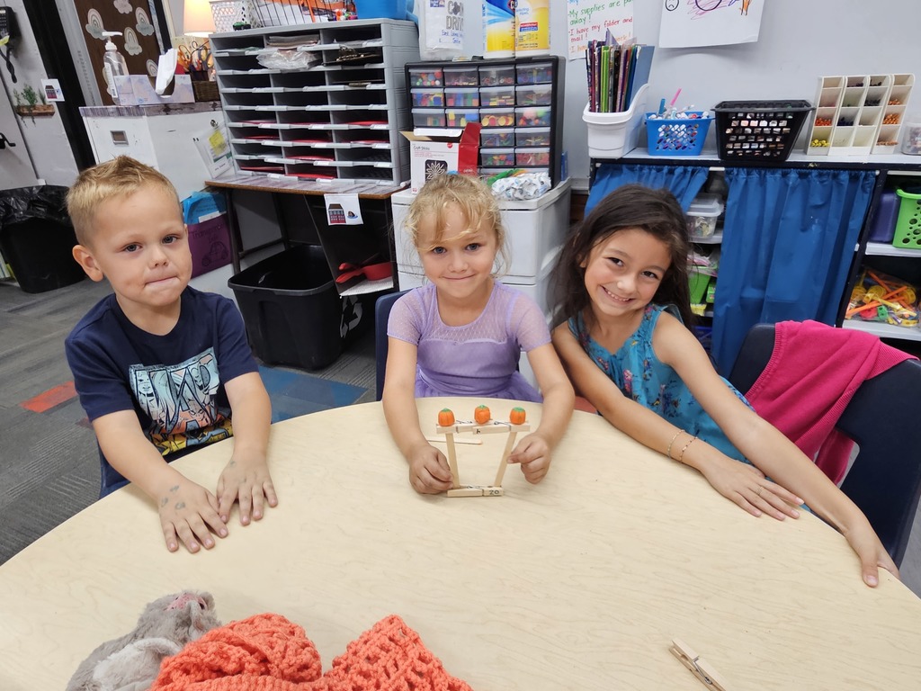 Three students showing off their 3 pumpkin gate