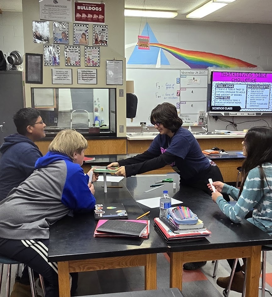 Four students building a table