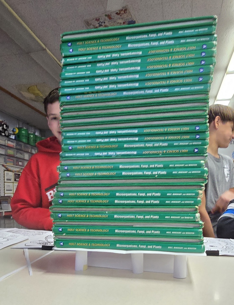 A huge stack of textbooks on a paper table