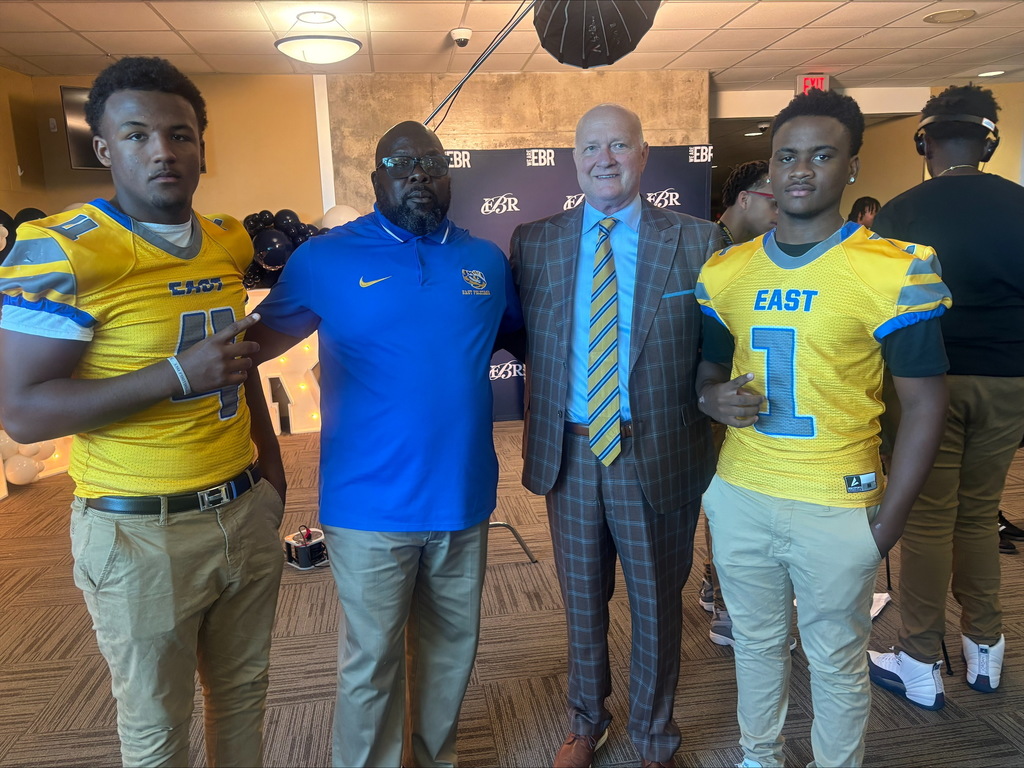 Two football players, a coach and a mayor.
