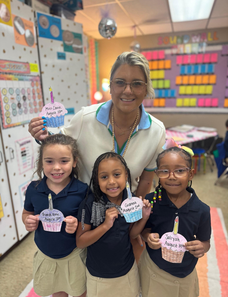 A teacher and three students holding birthday cupcakes.