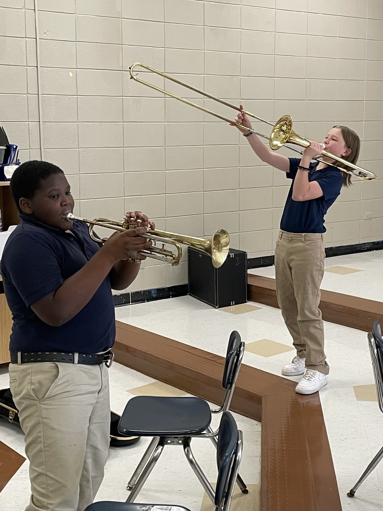 Students playing trombones and trumpets.