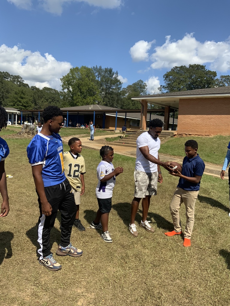 Students and an adult with a football.