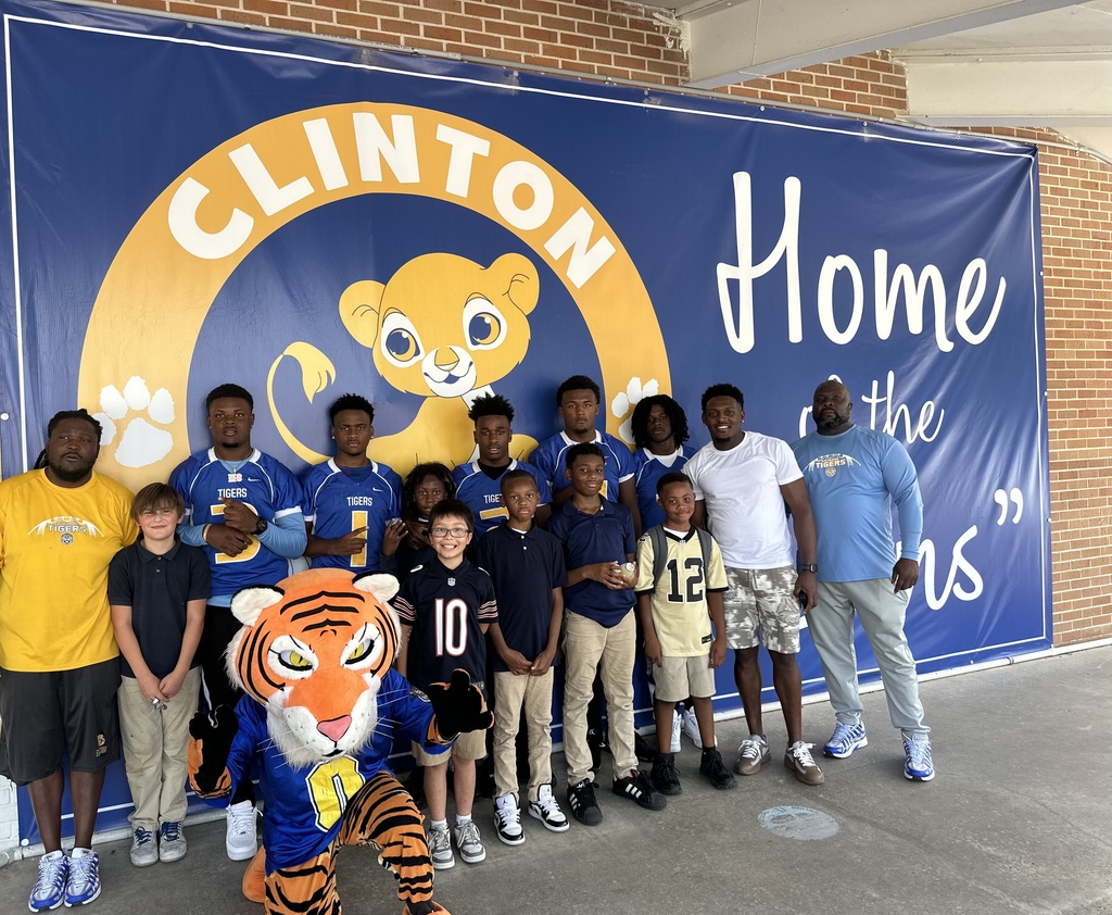 Students and adults in front of a banner.