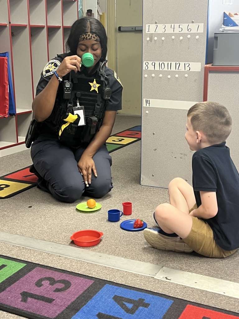 A resource officer and a child enjoy a tea break.