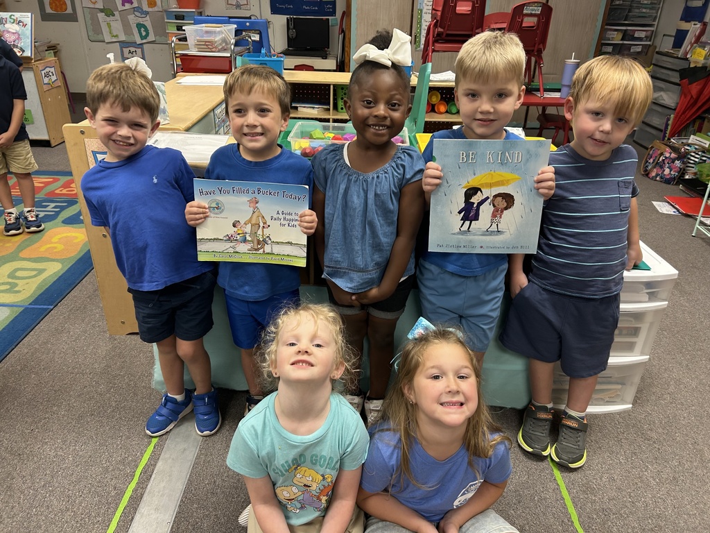 Students dressed in blue and holding books.