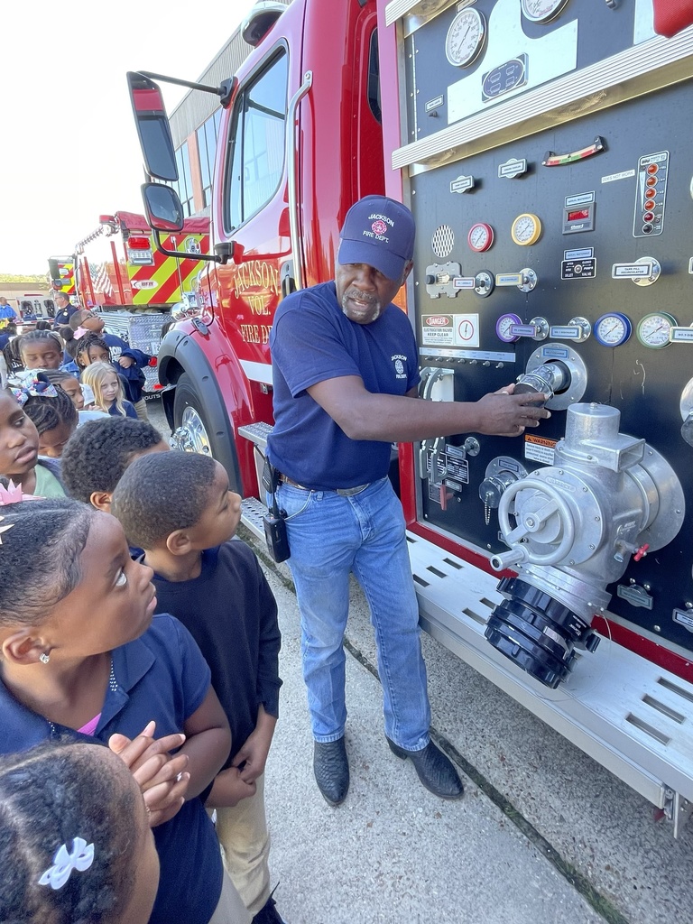 A man shows children a fire truck.