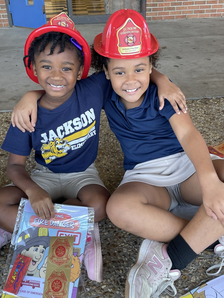 Children with fire safety resources and fire hats.