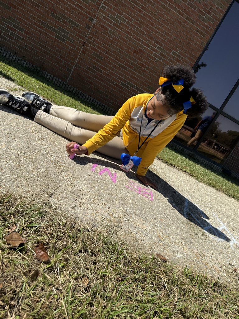Student writing a chalk message.