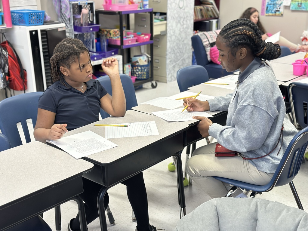 A high school student tutors an elementary student.