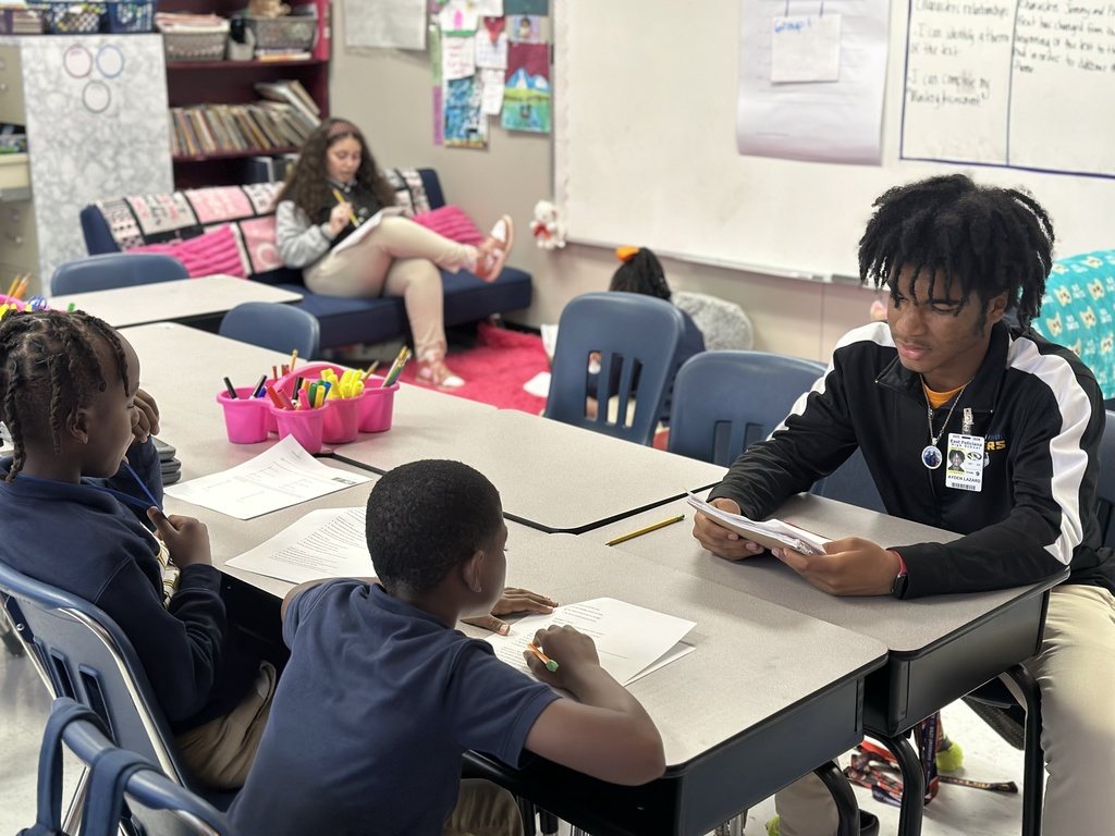 A high school student tutors an elementary student.