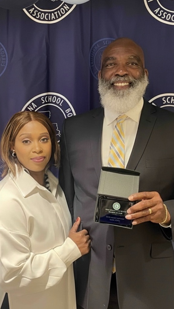 A man holding a plaque with a woman standing by him.