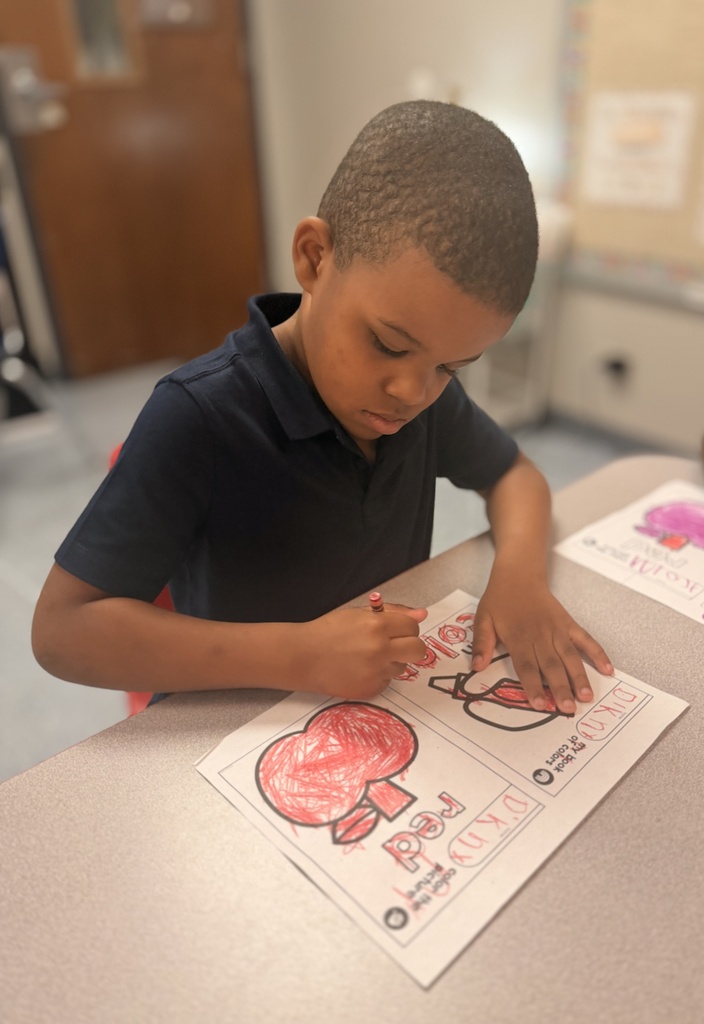 A student coloring an apple