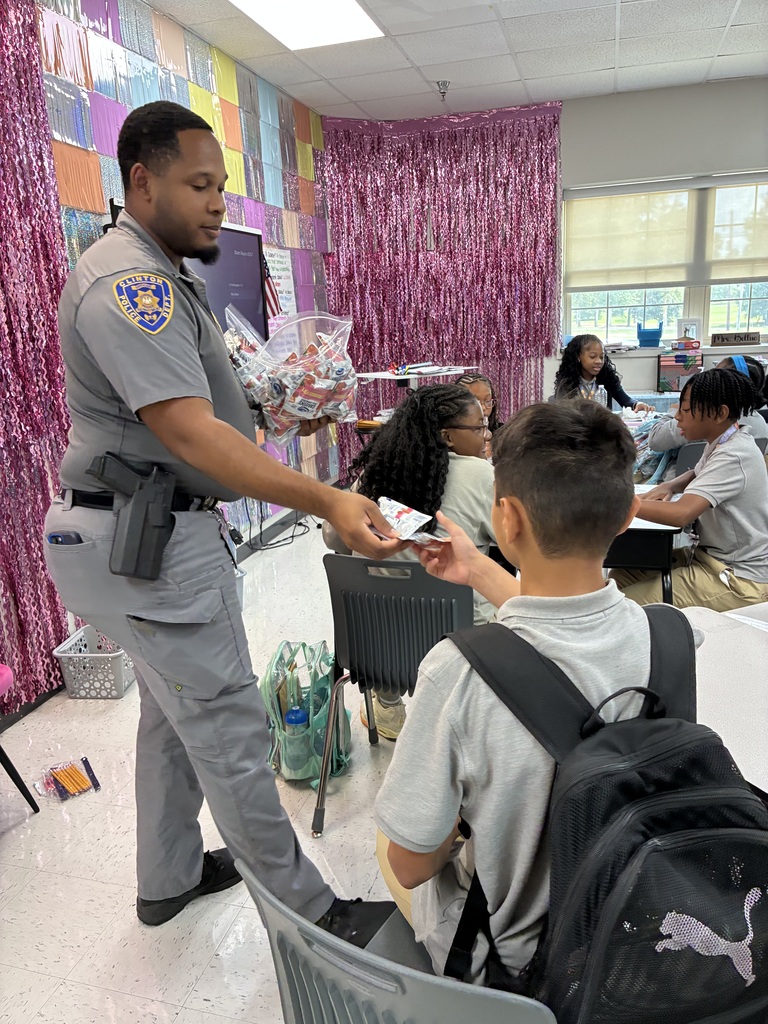A school resource officer passes out a snack