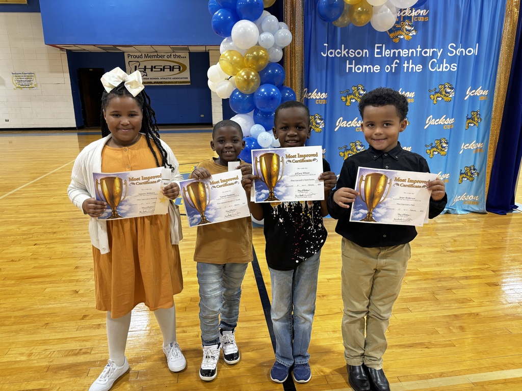 Four students holding most improved certificates