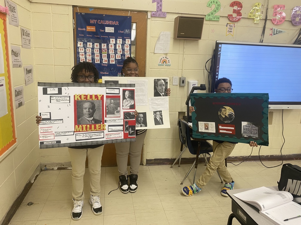 3 students holding up posters.