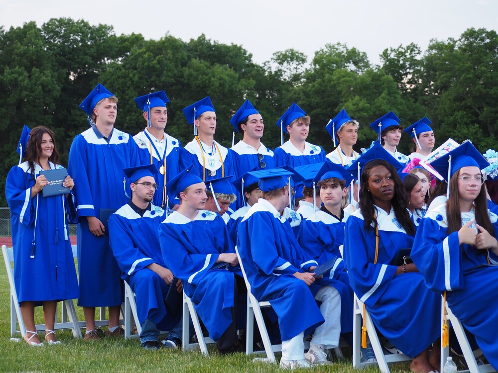 Last row of graduates standing