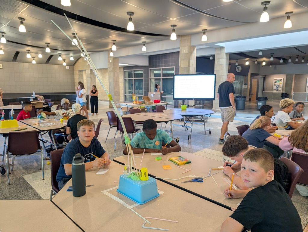 a group of male students write and look at their created tower work