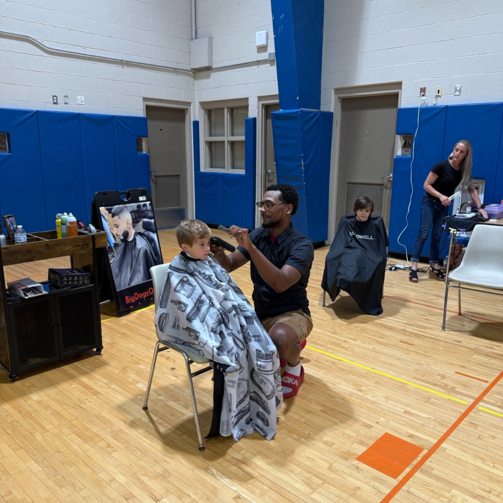 student gets haircut and sits in chair