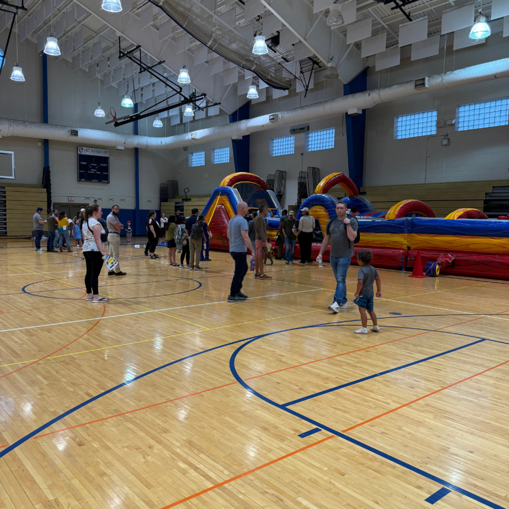 kids and families play on the bounce house in the gymnasium