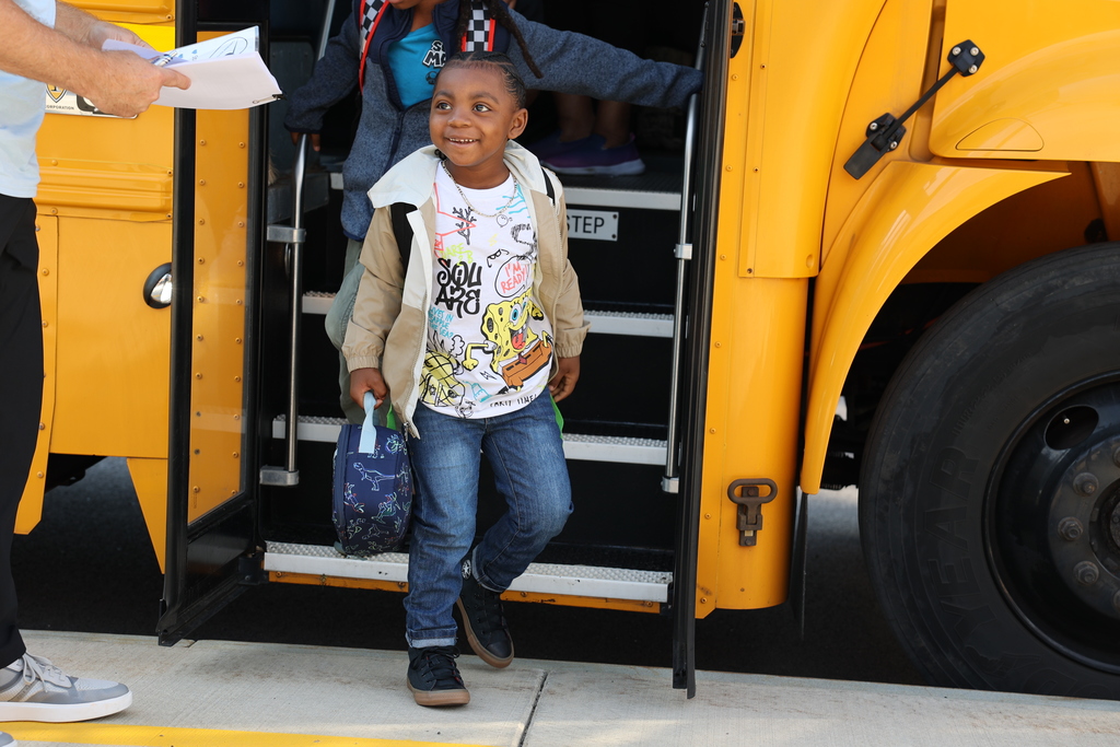Student happily leaves the bus excited