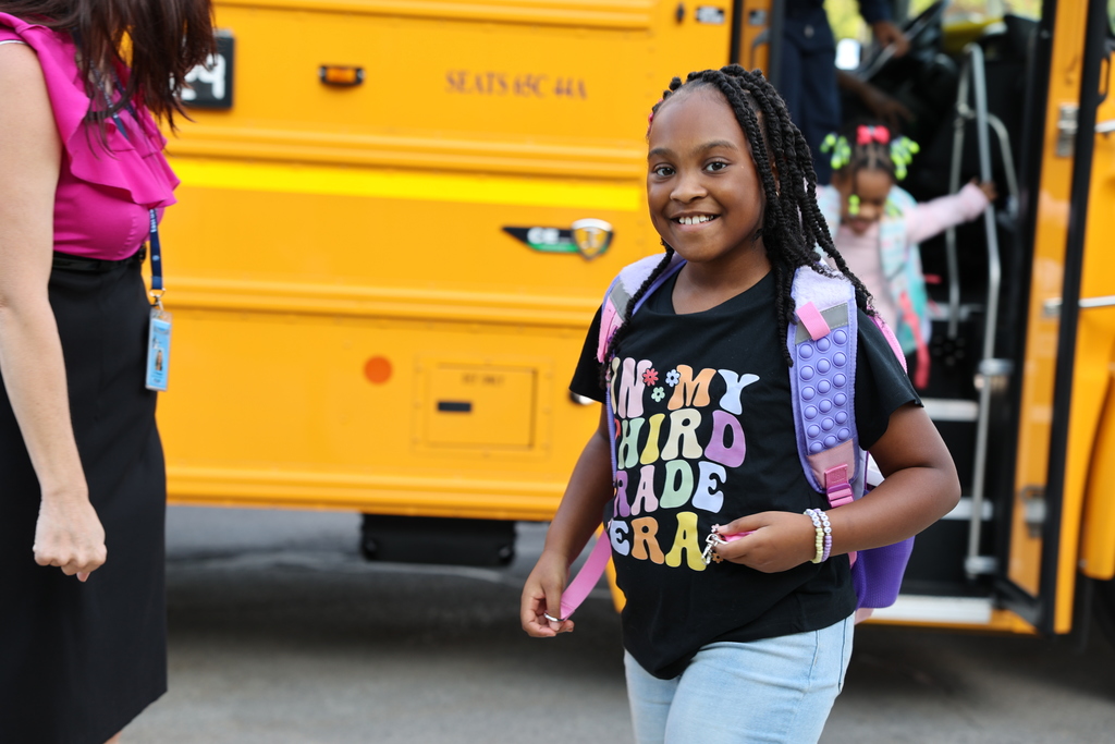student smiles getting off the bus