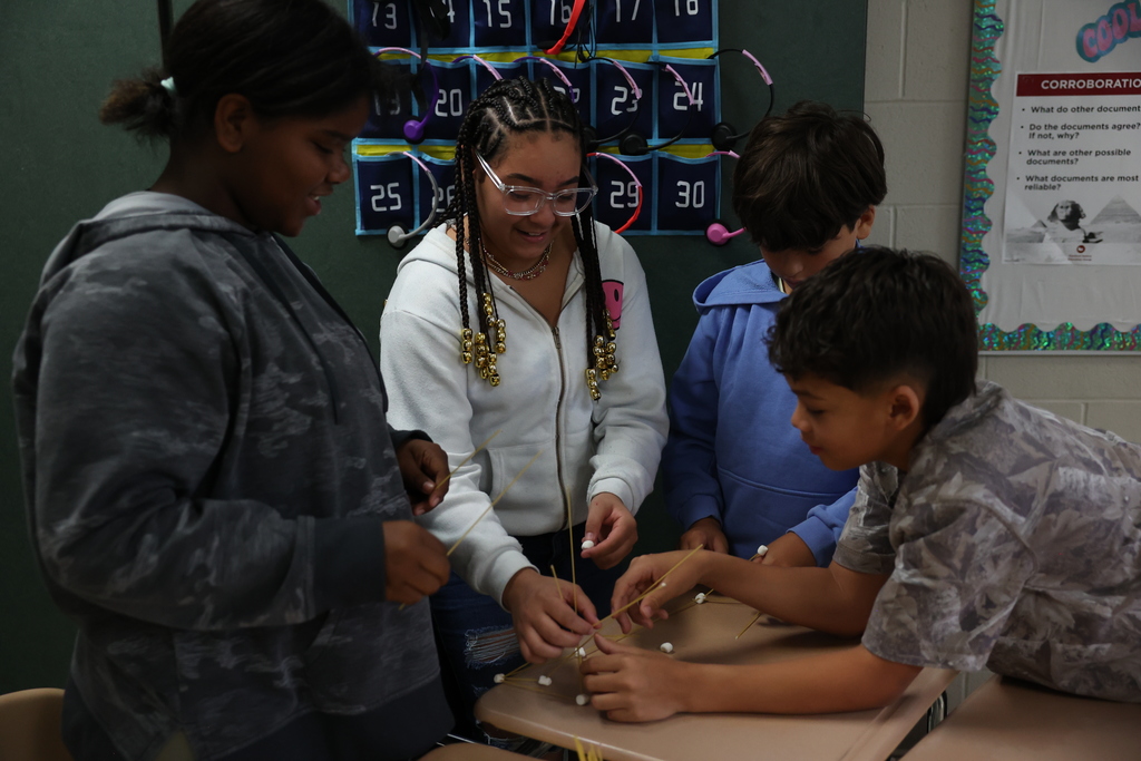 Four students work together to build a tower