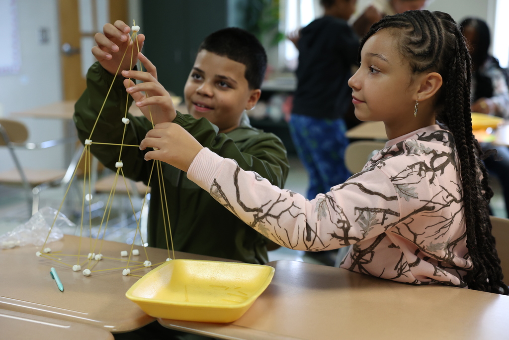 Students build towers made out of spaghetti and marshmellow, two hold the tower are they add new pieces