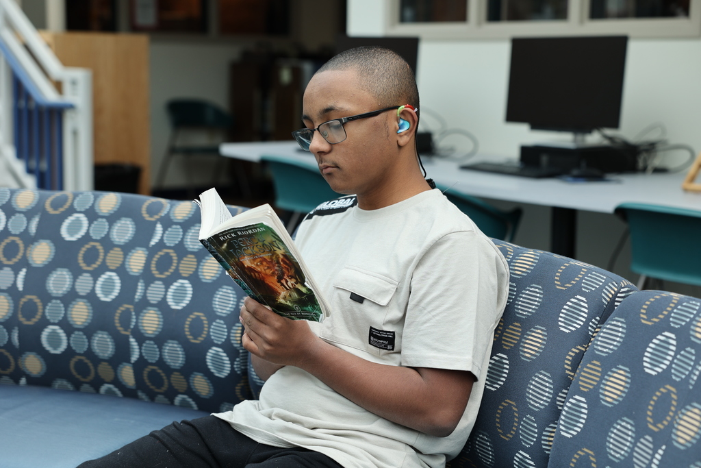 Student reads book on the couch