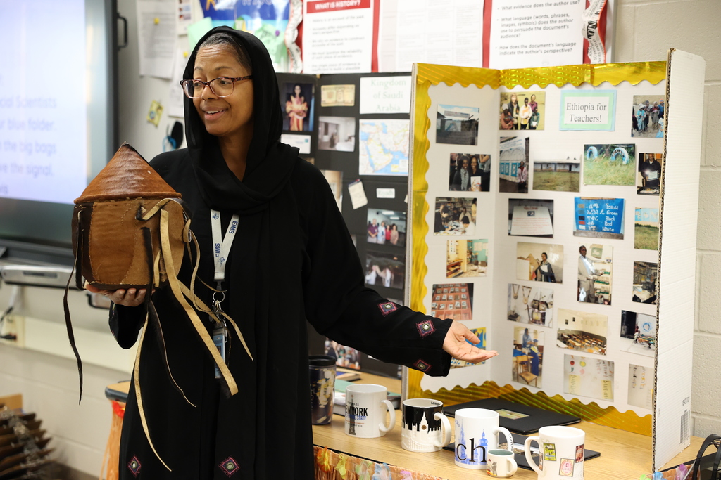 Ms Davis shows photos and an artifact from other countries